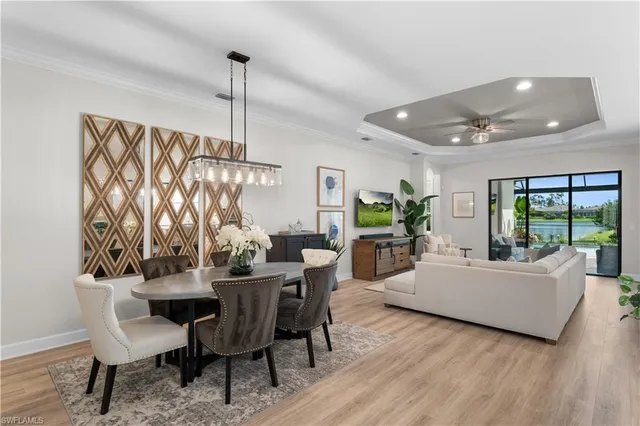 a dining room with furniture a chandelier and wooden floor