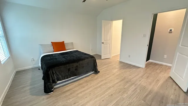a bedroom with a bed and wooden floor