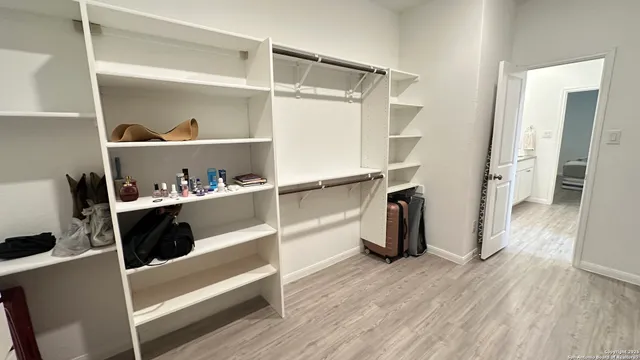 a view of walk in closet with empty racks