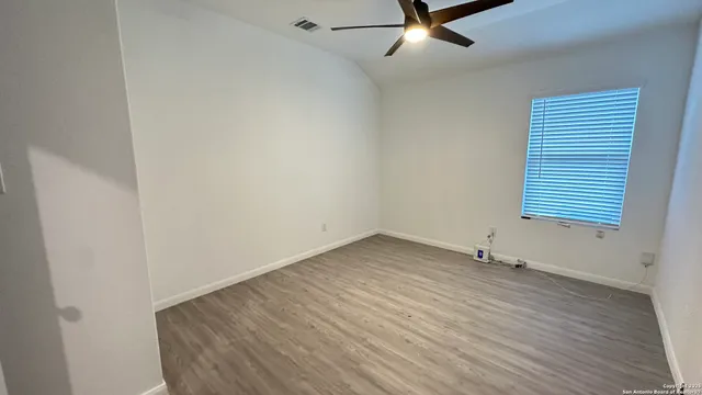 wooden floor in an empty room with a window