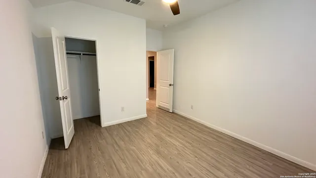 an empty room with wooden floor and closet
