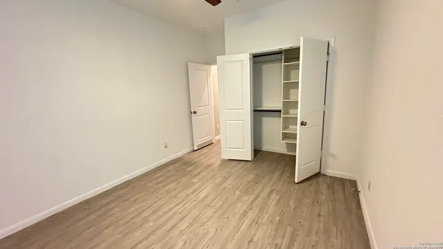 an empty room with wooden floor and closet