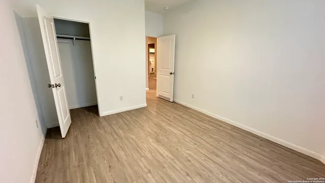 an empty room with wooden floor and closet