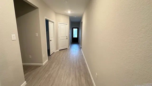 a view of a hallway with wooden floor