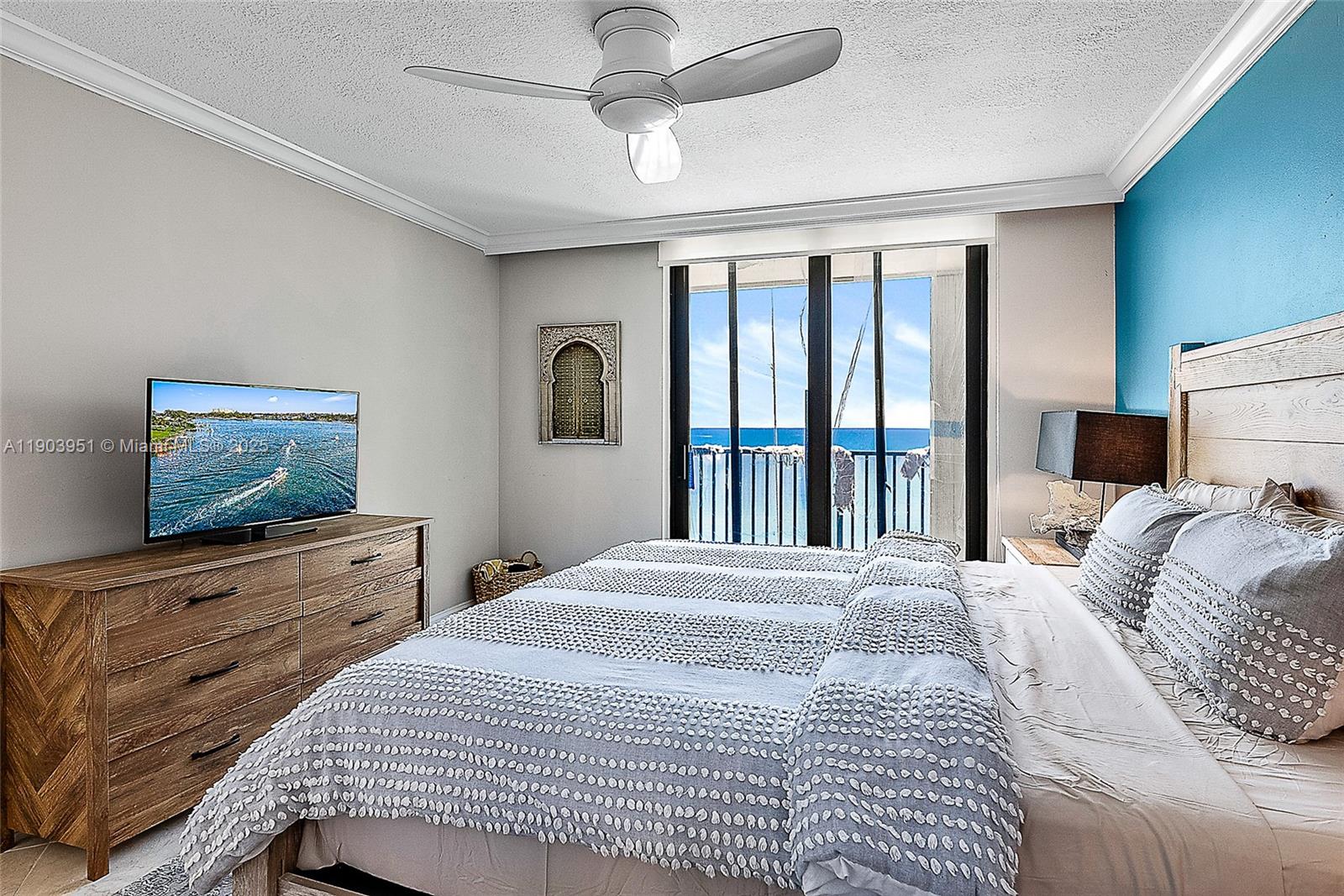 400 Ocean Trail Way, Unit 1005 Jupiter, FL 33477 - Photo 11 of 23 a bedroom with a large bed and a flat tv screen