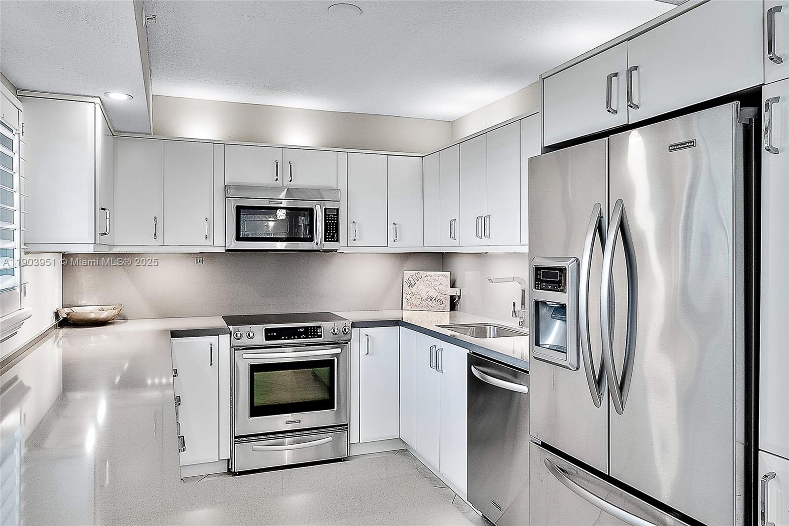 400 Ocean Trail Way, Unit 1005 Jupiter, FL 33477 - Photo 7 of 23 a kitchen with refrigerator a microwave and cabinets