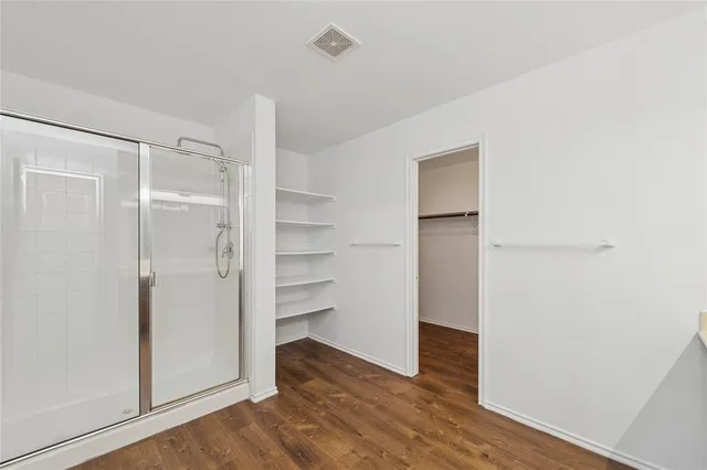 a view of walk in closet with wooden floor