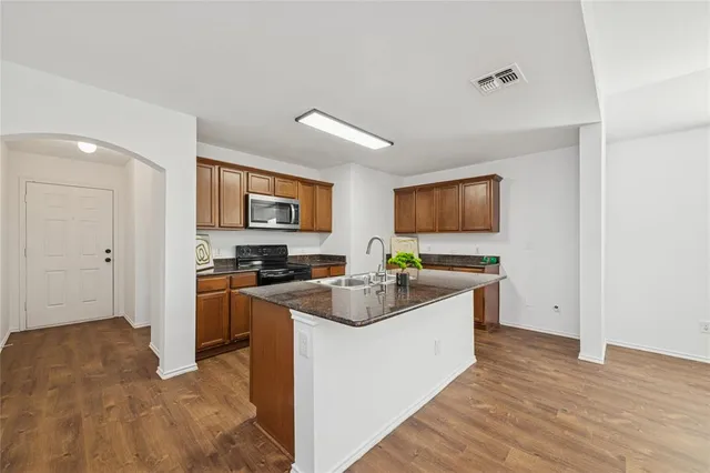 a kitchen with stainless steel appliances granite countertop a sink stove and refrigerator