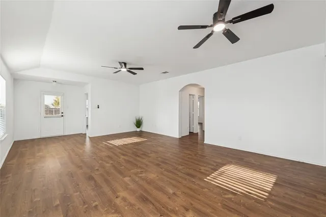 a view of empty room with wooden floor