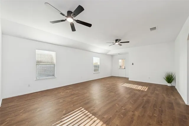 an empty room with fan and windows