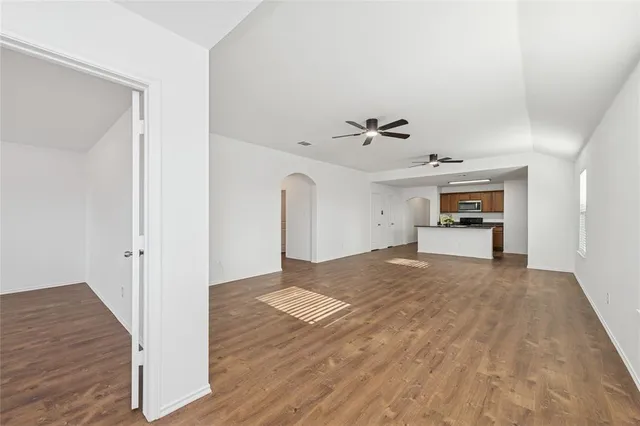 a view of empty room with wooden floor and window