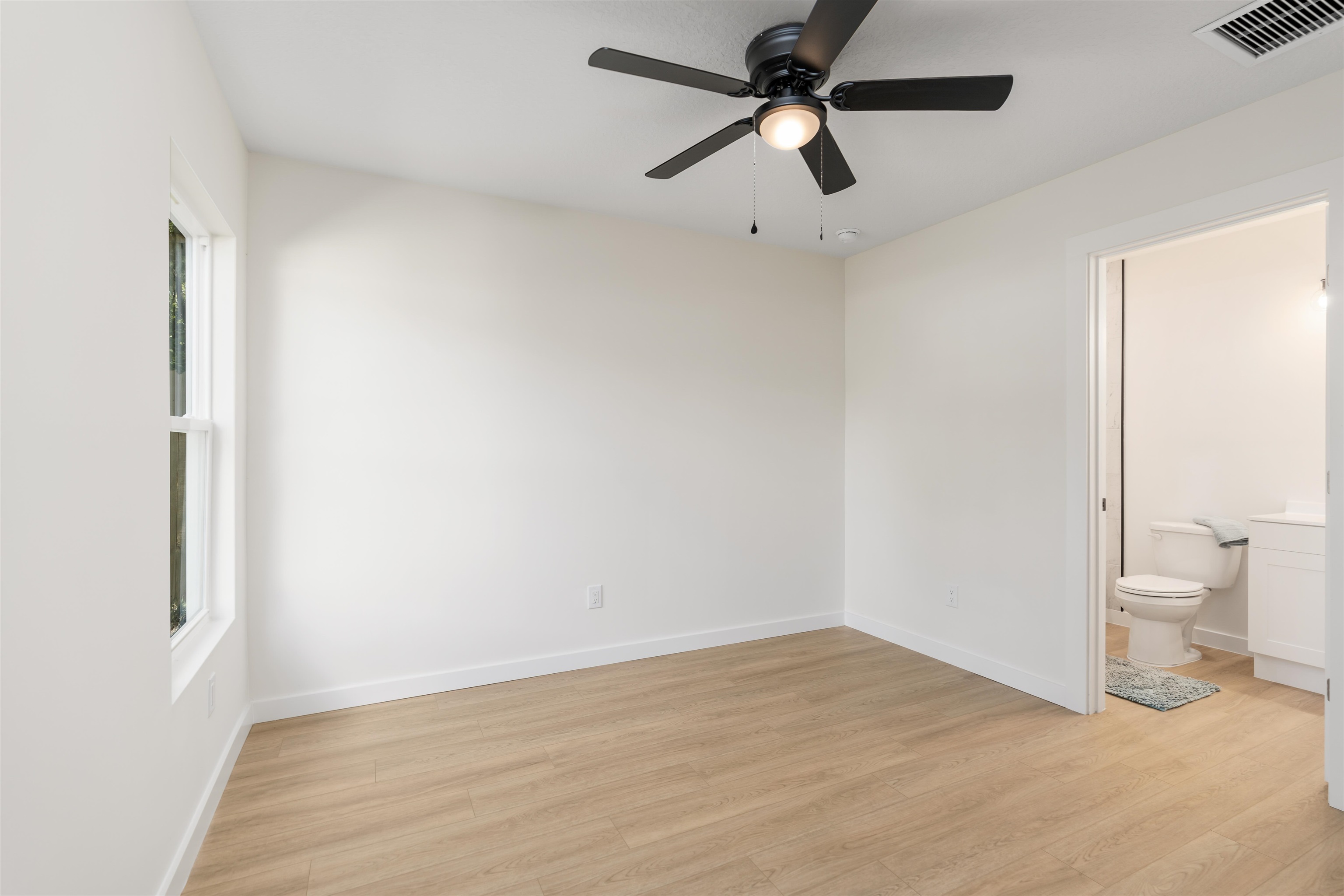 816 West 9th Street St. Augustine, FL 32084 - Photo 19 of 28 a view of a room with a wooden floor and a ceiling fan
