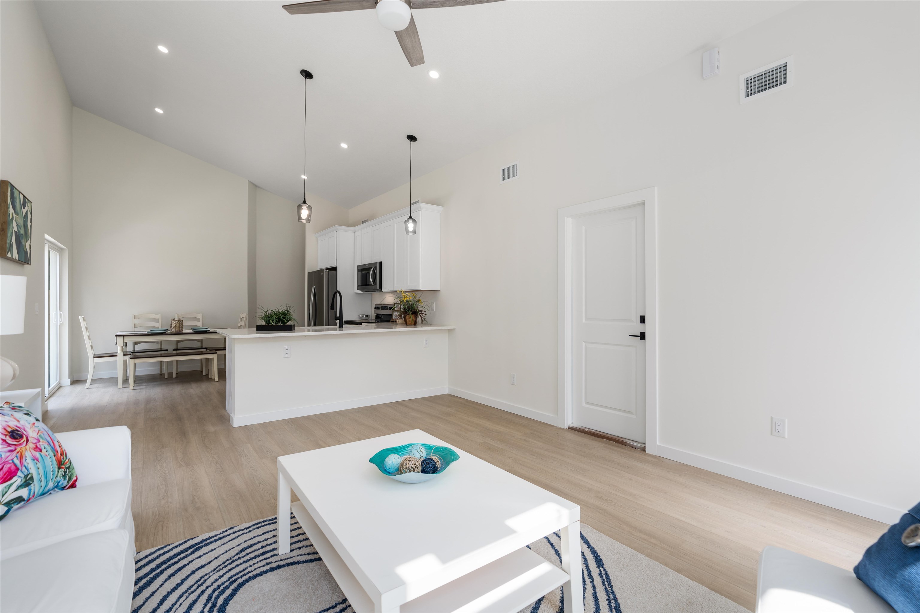816 West 9th Street St. Augustine, FL 32084 - Photo 5 of 28 a living room with kitchen island furniture and a wooden floor