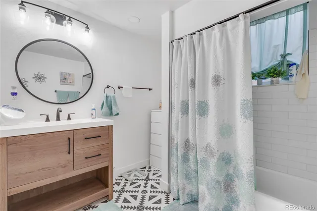 a bathroom with a sink a mirror and a shower curtain