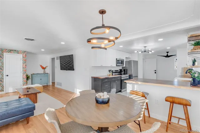 a kitchen with sink refrigerator dining table and chairs