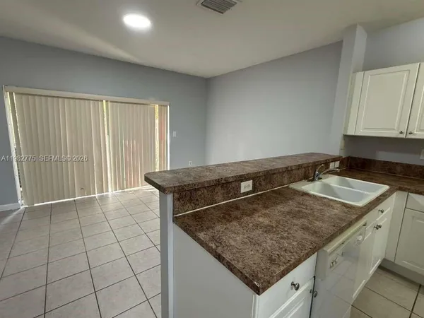 a kitchen with granite countertop a sink and cabinets