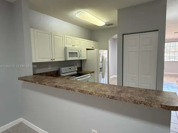 a kitchen with stainless steel appliances granite countertop a sink a refrigerator and a granite counter tops