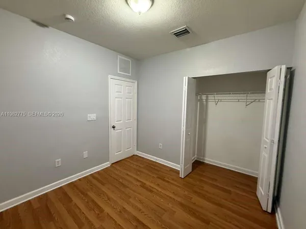 an empty room with wooden floor and closet
