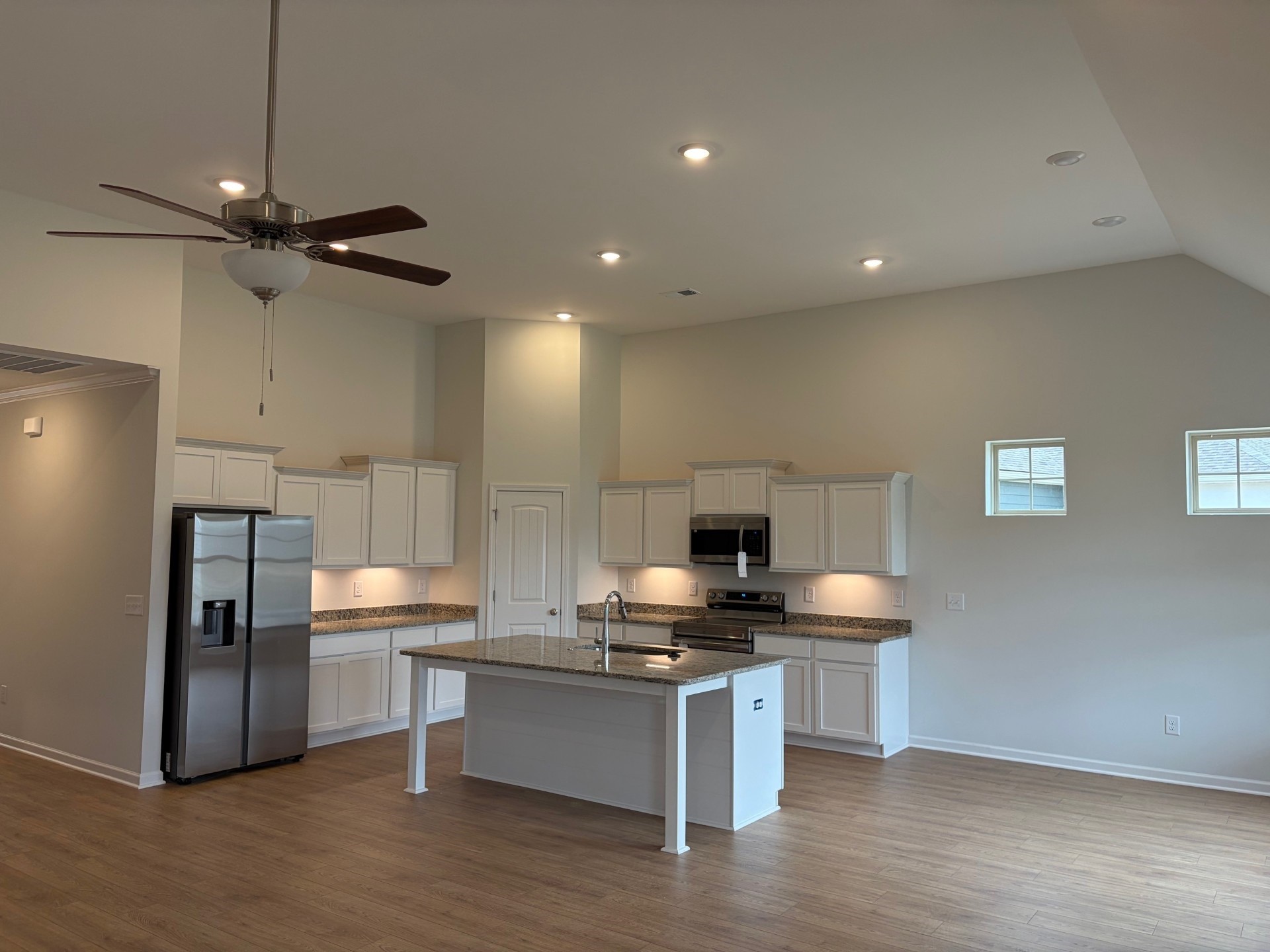 7019 Sully Court Fairview, TN 37062 - Photo 4 of 9 a kitchen with stainless steel appliances granite countertop a sink a refrigerator and a stove with wooden floor