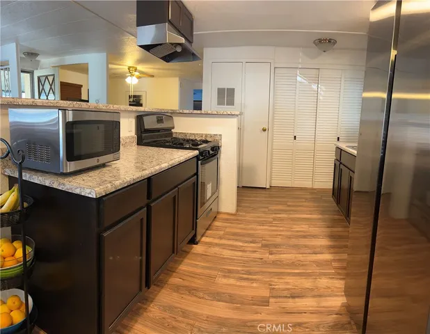 a kitchen with stainless steel appliances kitchen island granite countertop a refrigerator and a stove top oven