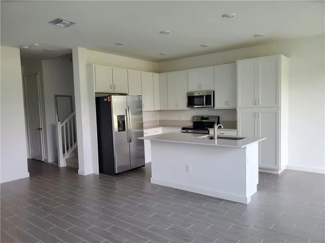 a kitchen with stainless steel appliances granite countertop a refrigerator stove a sink and a microwave