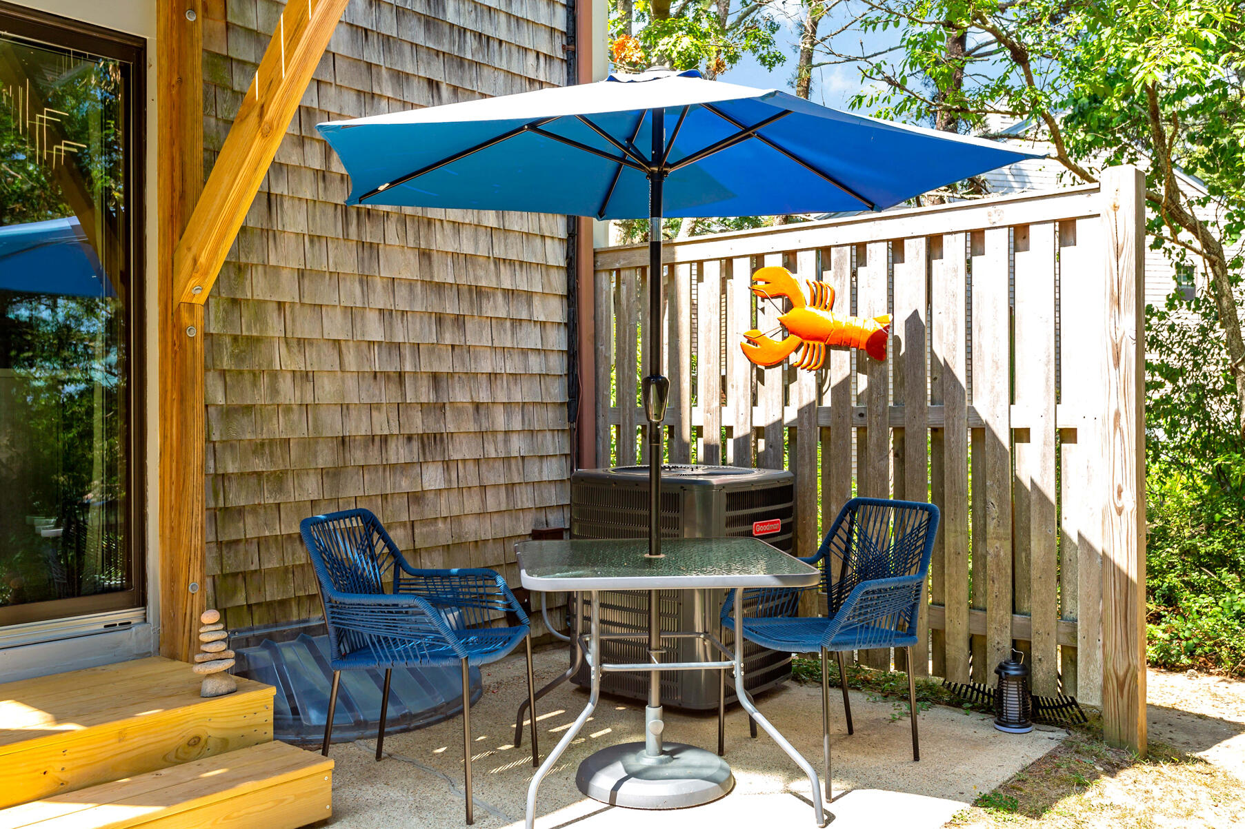 195 Falmouth Road, Unit 16A Mashpee, MA 02649 - Photo 35 of 43 a patio with a table and chairs under an umbrella