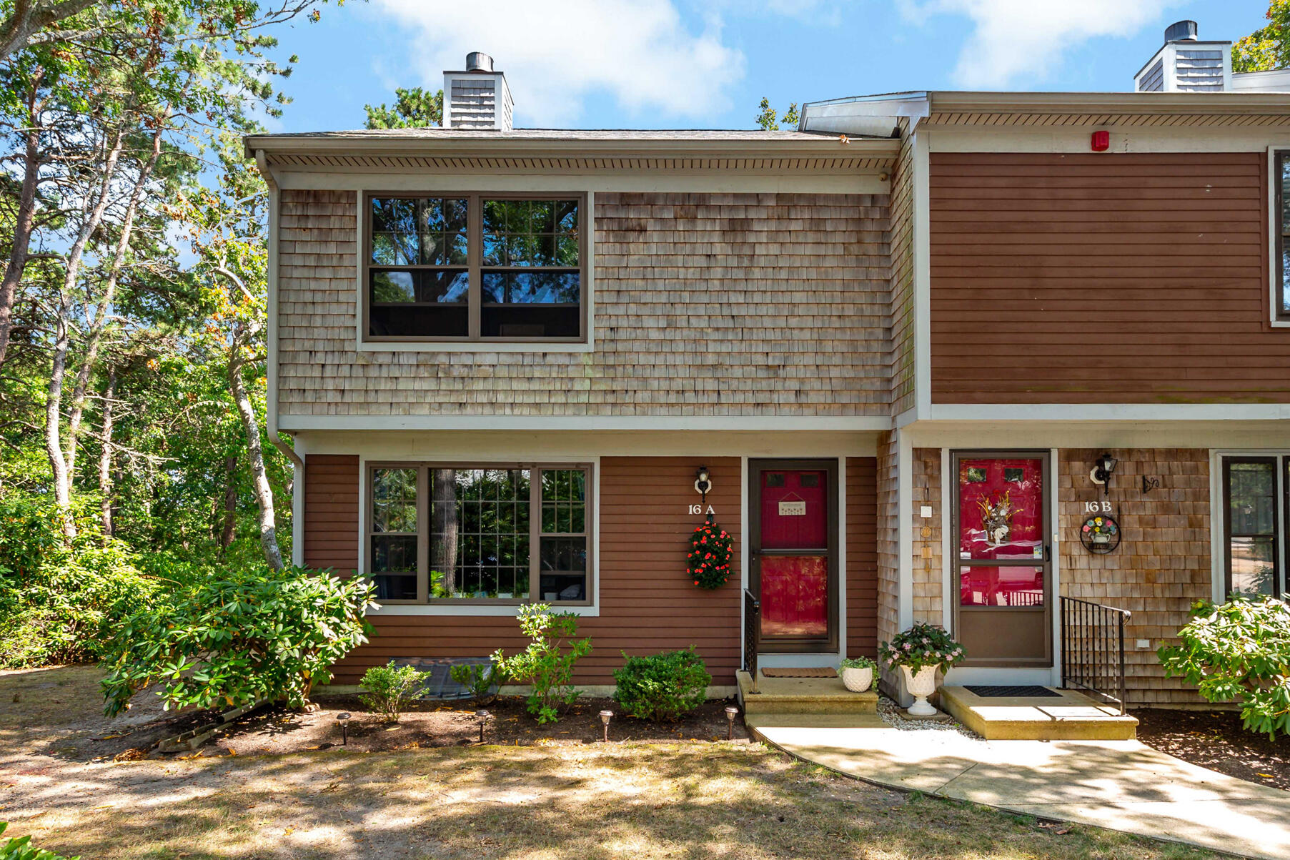 195 Falmouth Road, Unit 16A Mashpee, MA 02649 - Photo 39 of 43 a front view of a house with garden