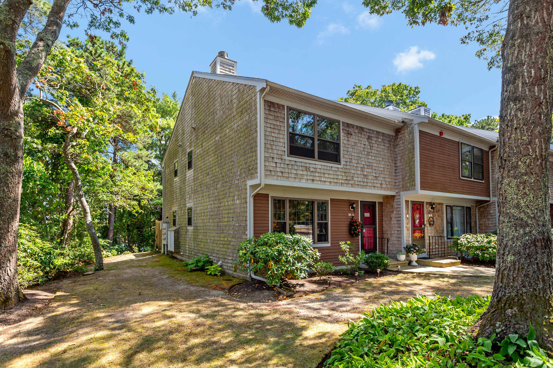 195 Falmouth Road, Unit 16A Mashpee, MA 02649 - Photo 40 of 43 a front view of a house with garden