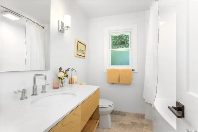 a bathroom with a sink a toilet and mirror