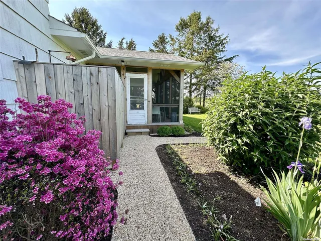 a view of a pathway that has a flower garden