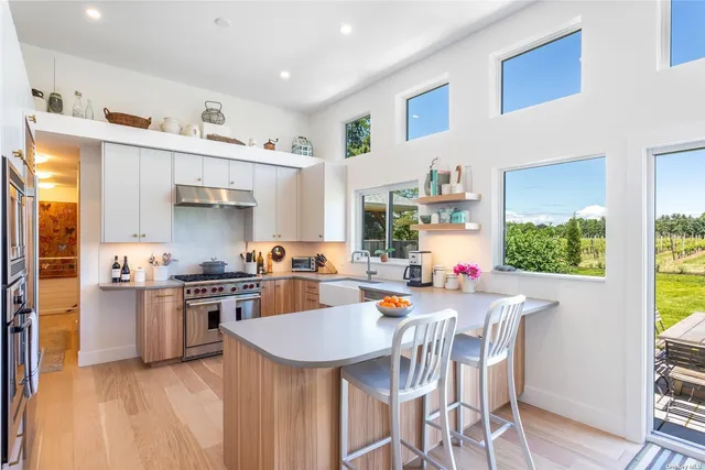 a kitchen with stainless steel appliances a table and chairs in it