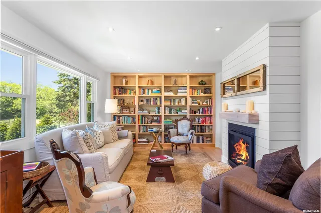 a living room with furniture fireplace and a large window
