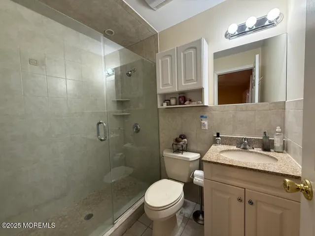 a bathroom with a granite countertop toilet sink and shower