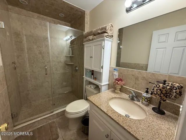 a bathroom with a granite countertop sink toilet and shower
