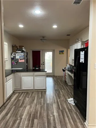 a kitchen with stainless steel appliances a refrigerator and a stove top oven