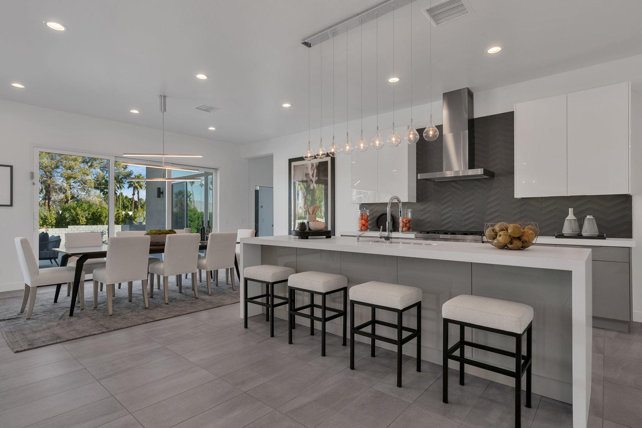 71374 Biskra Road Rancho Mirage, CA 92270 - Photo 10 of 75 a kitchen with lots of chairs a sink dishwasher a dining table and chairs with wooden floor