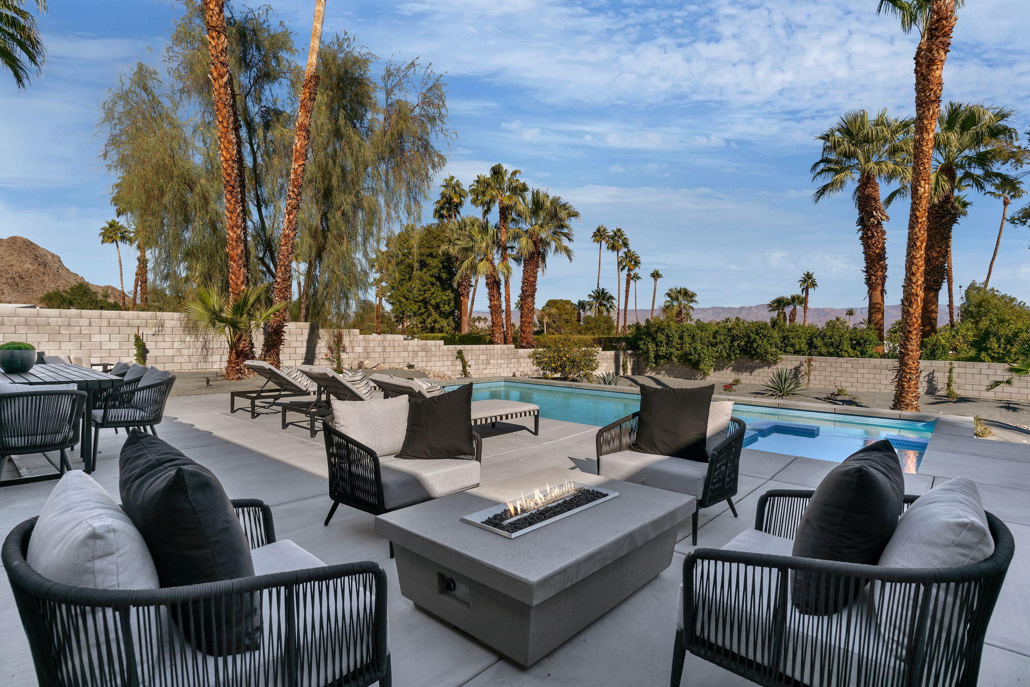 71374 Biskra Road Rancho Mirage, CA 92270 - Photo 37 of 75 a view of a patio with couches potted plants and a palm tree
