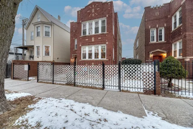 a front view of a house with iron fence