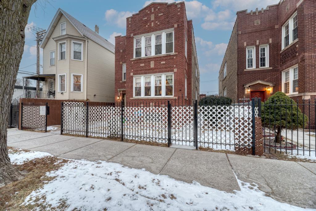 a front view of a house with iron fence
