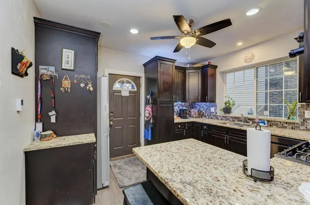 a kitchen with stainless steel appliances kitchen island granite countertop a sink stove and refrigerator