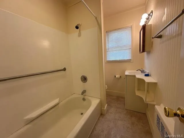 a bathroom with a tub a sink and a shower