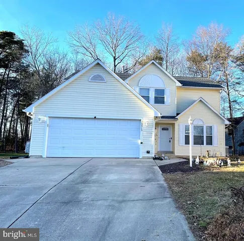 a view of a yard in front of a house with large trees