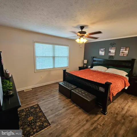 a bedroom with a bed dresser and a window