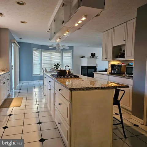 a kitchen with granite countertop a sink stove and cabinets