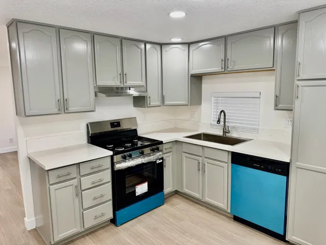 a kitchen with cabinets appliances and a sink
