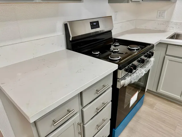 a stove top oven sitting inside of a kitchen