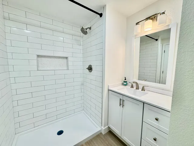 a bathroom with a shower sink and mirror