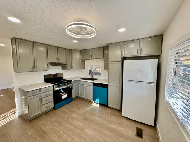 a kitchen with a refrigerator and a stove top oven