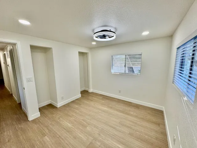 an empty room with wooden floor and entrance