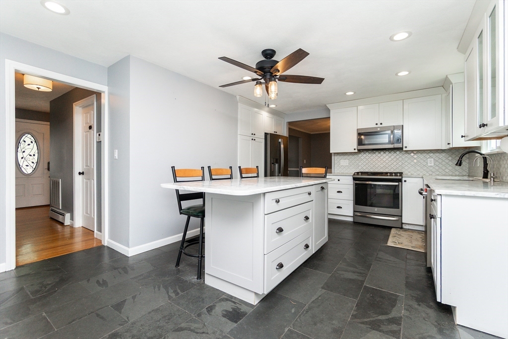 63 Bow Street Saugus, MA 01906 - Photo 9 of 42 a kitchen with kitchen island granite countertop a sink and stainless steel appliances